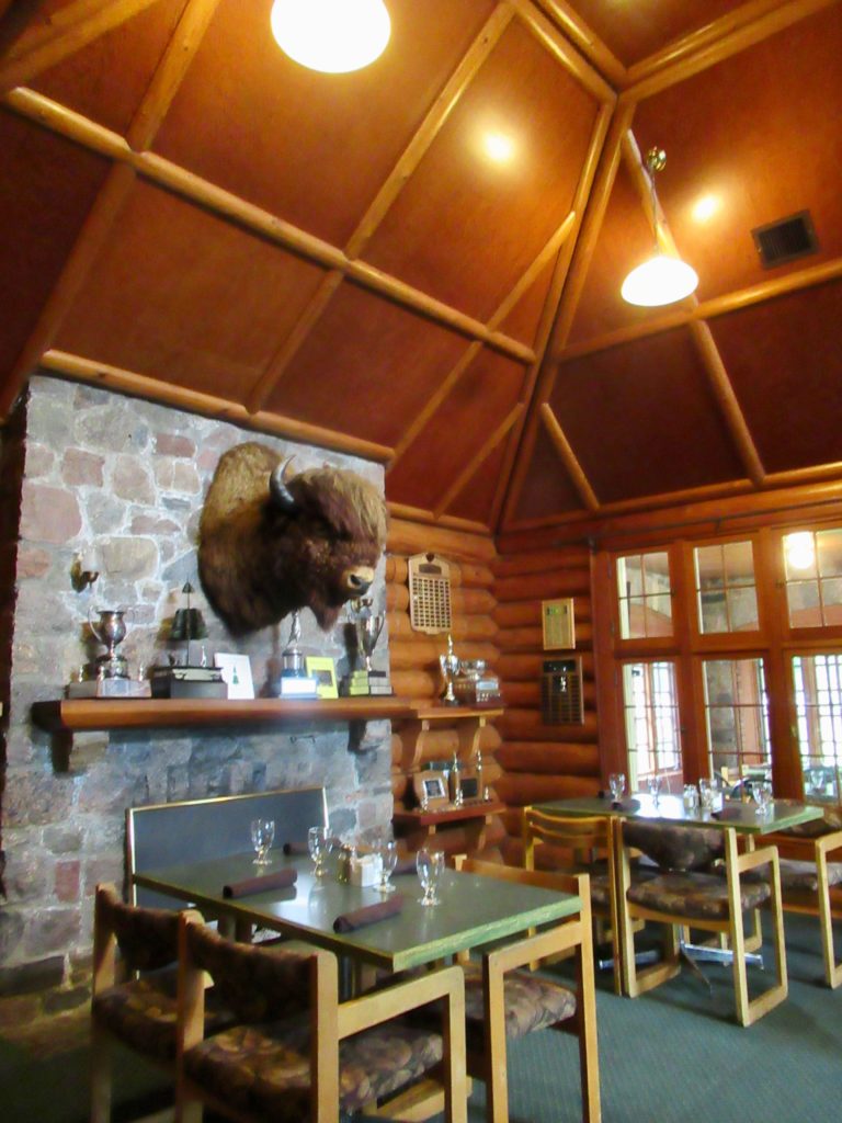 Interior of clubhouse with stone fireplace and wood panel ceiling