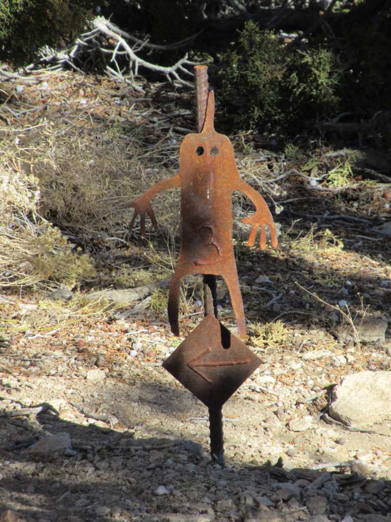 Metal marker of an anthropomorphic image on a rebar post pounded into the ground