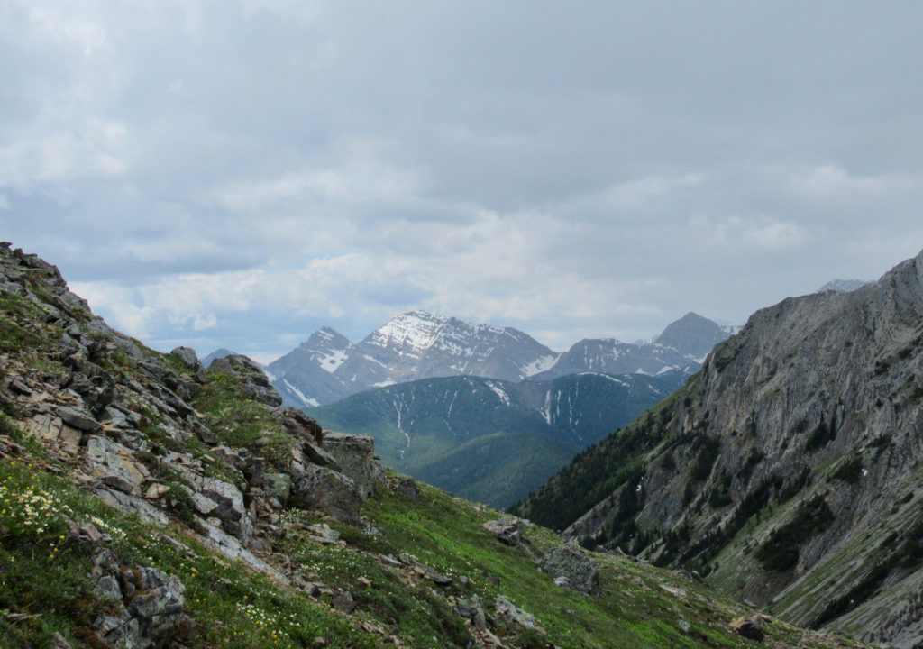 Mountain slopes with distant mountains and storm clouds in background