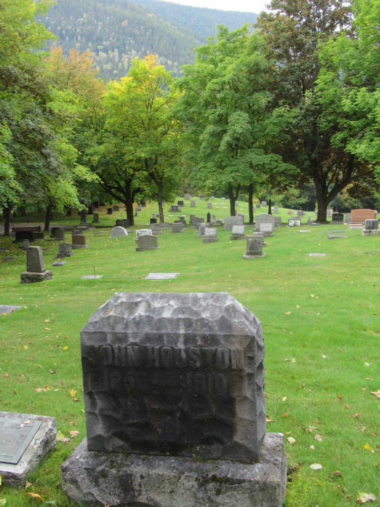 Weathered grey headstone read: John Houston 1850-1910