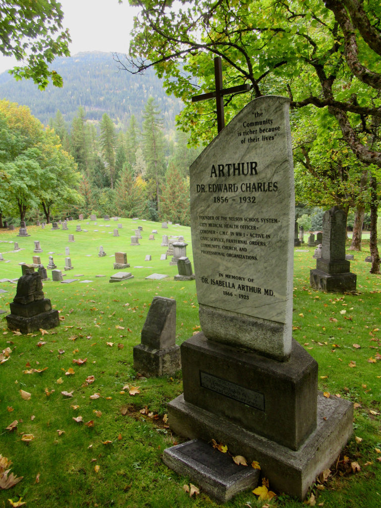 Headstone in graveyard reads: ARTHUR Dr Edward Charles 1856-1932