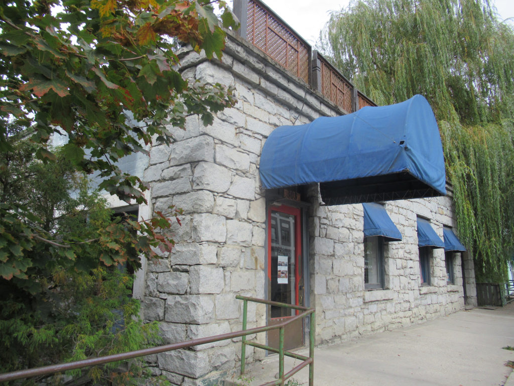 Stone building with blue canopies over windows