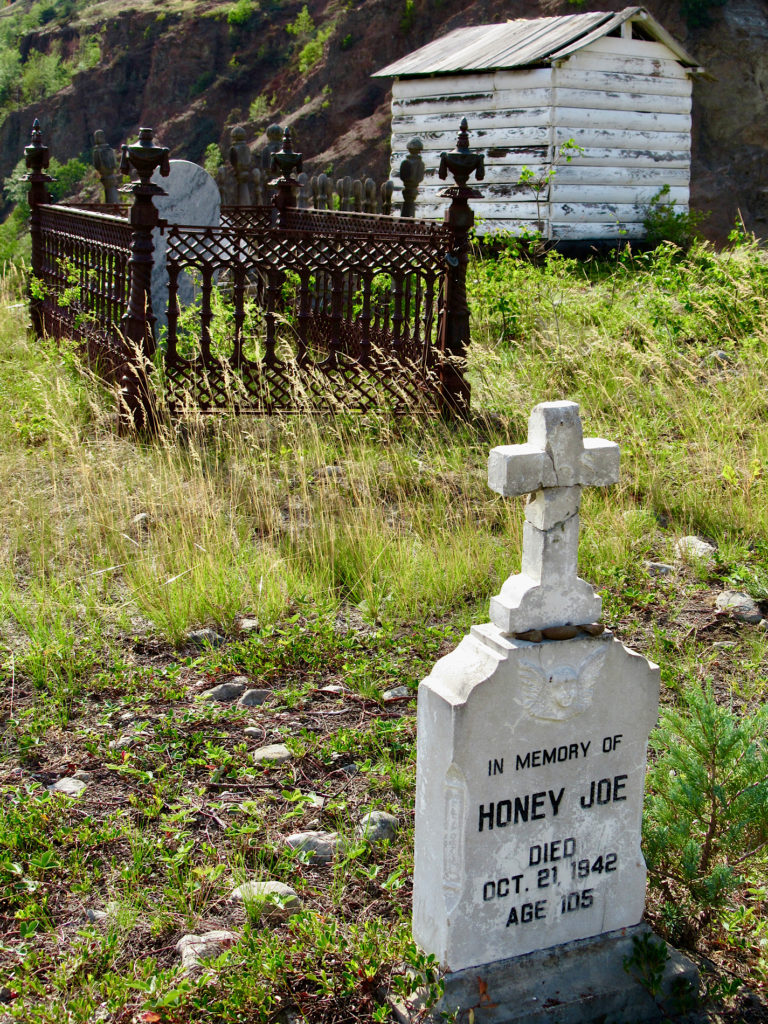 Historic graveyard with prominent light-colour headstone reading: In memory of Honey Joe. Died Oct 21 1943. Age 105.
