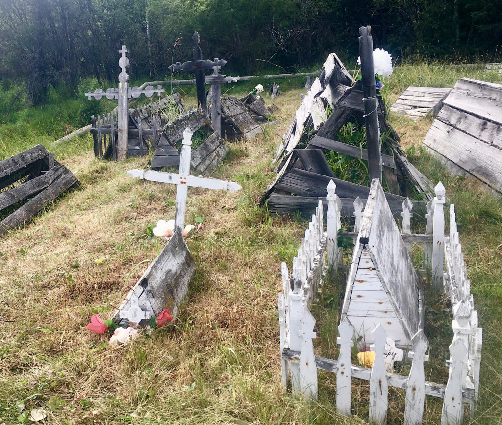 White, wooden roofed graves in a First Nations burial ground.