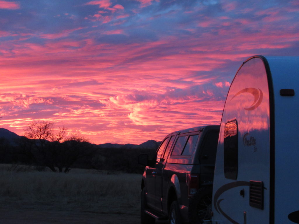 Brilliant pink sunset reflecting on truck and trailer.