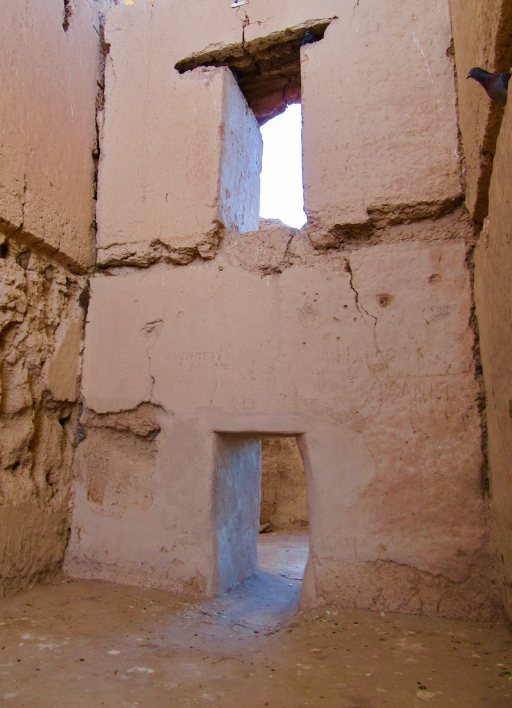 Ancient, two-storey, rock and mud structure with two large square doorways.