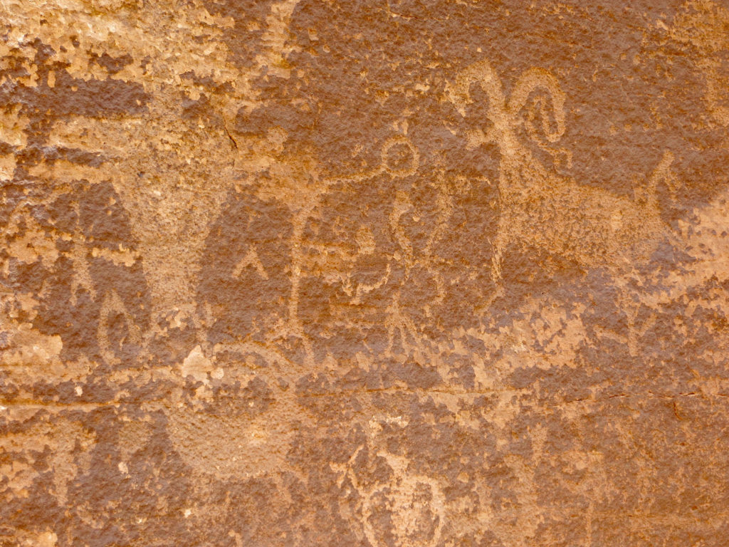 Etched figures on red sandstone.