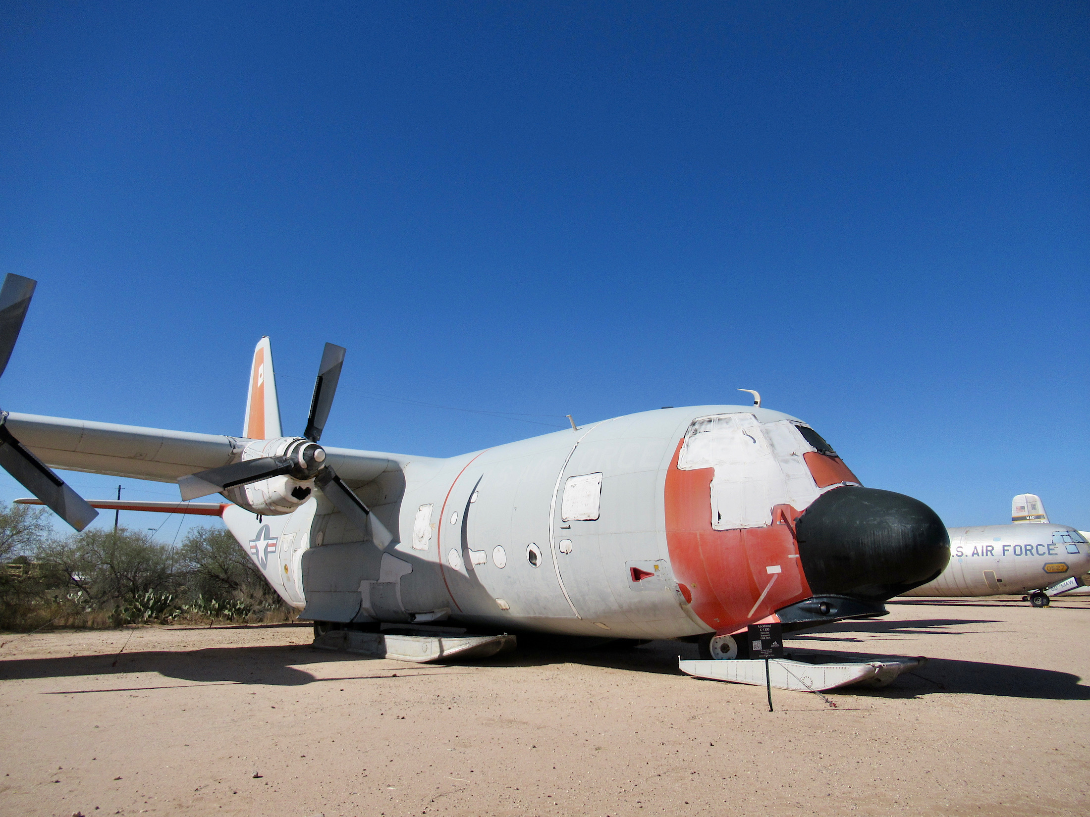 Large grey plane with skids for landing on snow or ice; painted grey with red front paint and bulbous "nose-like projection."