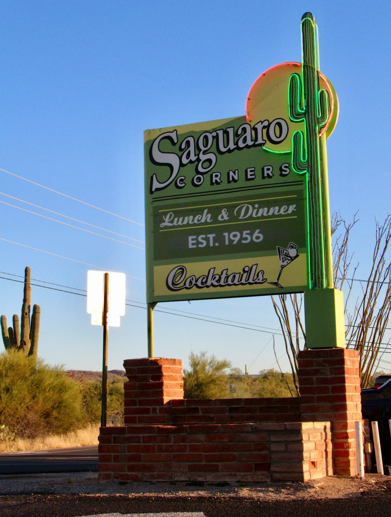 Neon sign of a Saguaro cactus with text reading: Saguaro Corners Lunch & Dinner Est. 1956 Cocktails