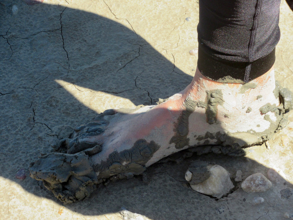 Woman's foot caked in mud.
