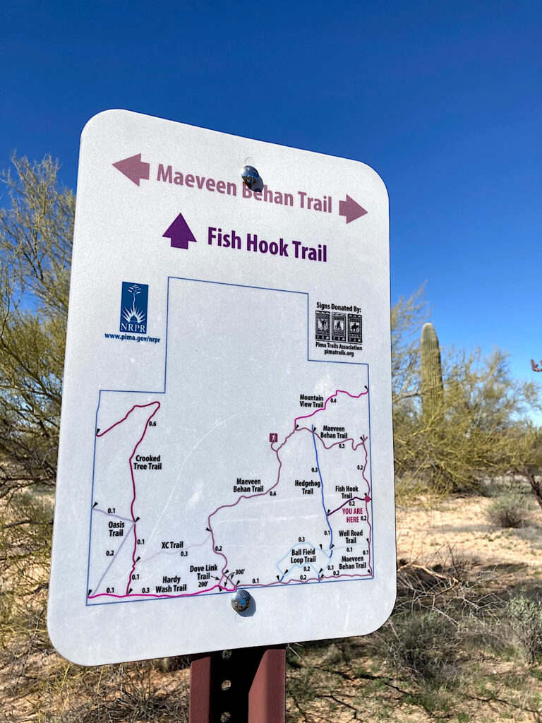 Trail sign with text reading: Maven Behan Trail and Fish Hook Trail