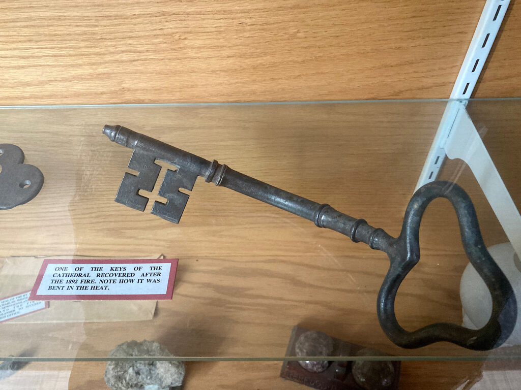 Bent metal key in a display case.