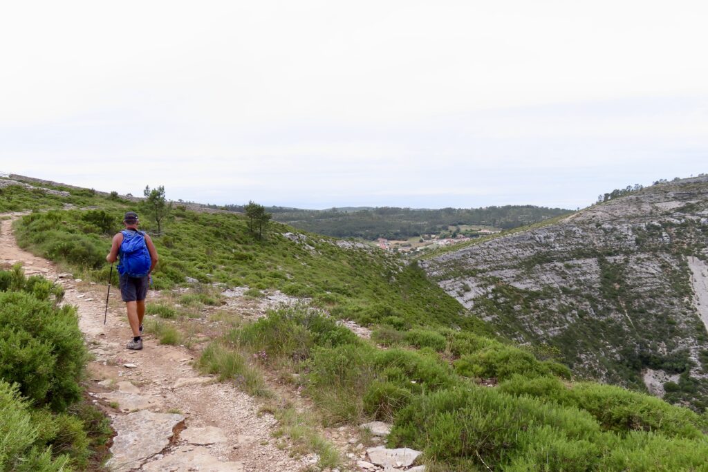 Man hiking path beside natural rock amphitheatre