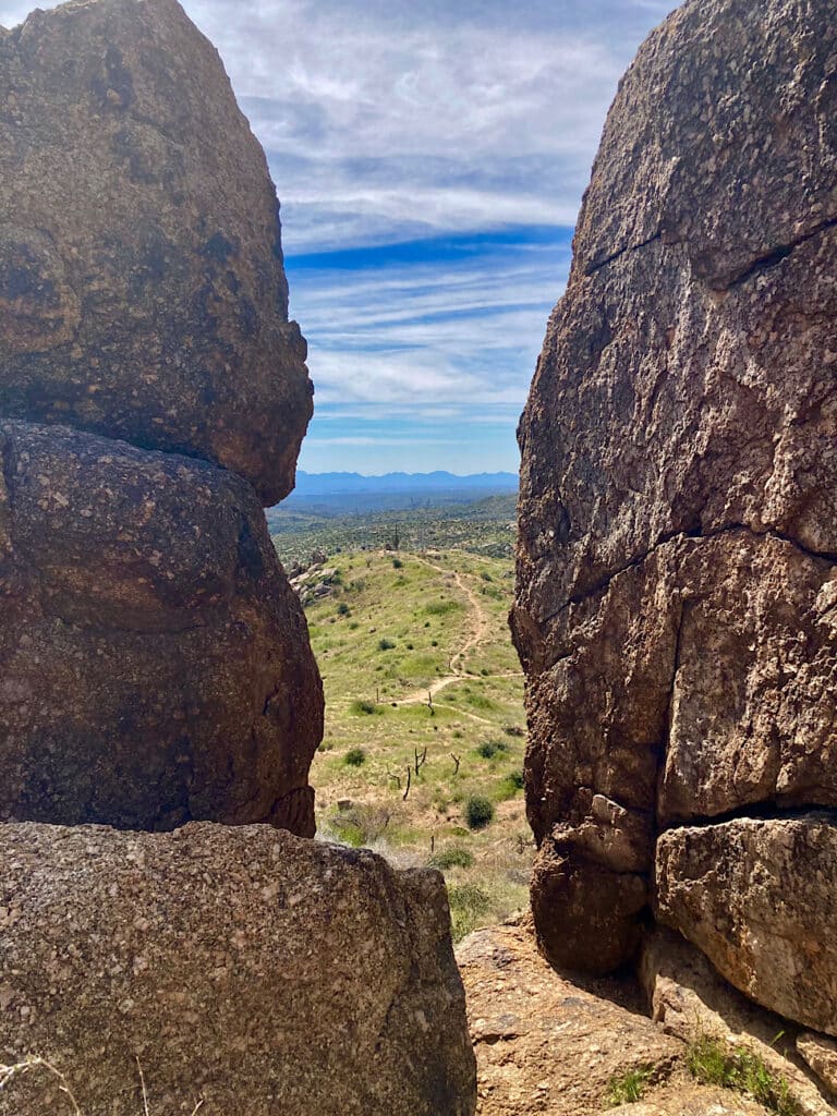 Looking out over desert landscape between two large boulders.