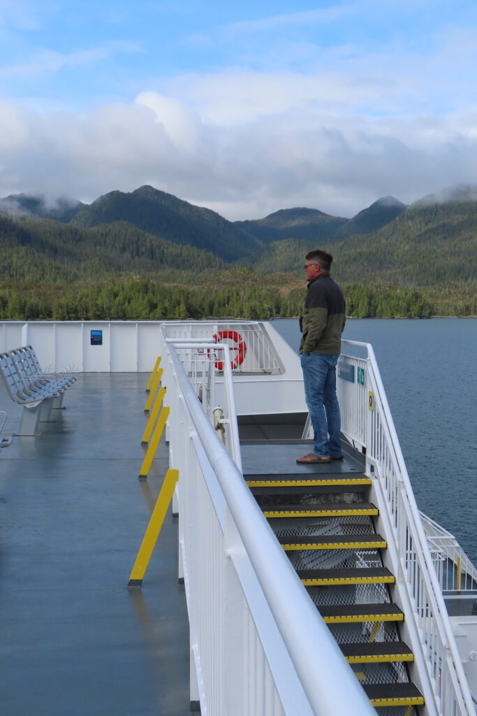 Man standing near top of stair on a boat.
