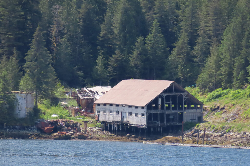 Large, rundown building on shore.