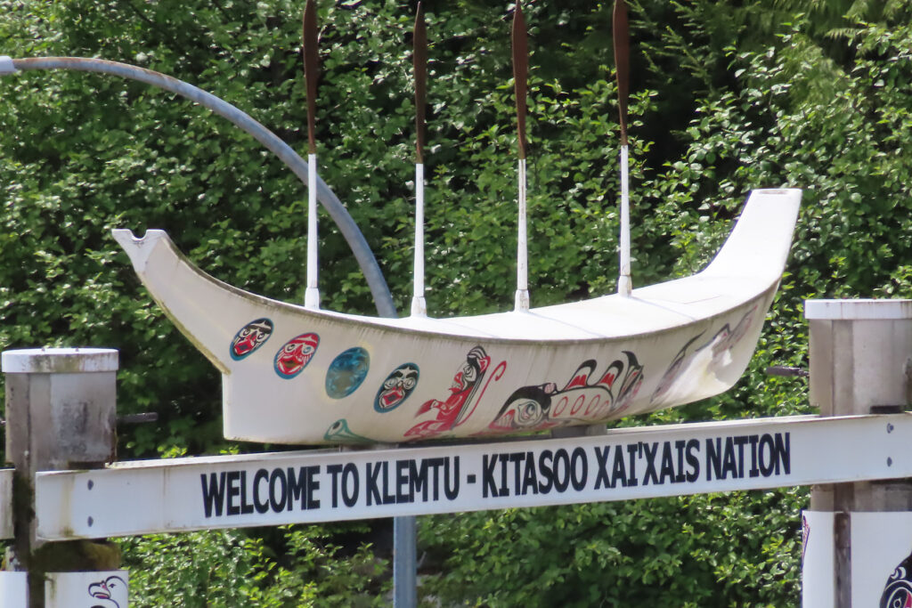 First Nations traditional canoe on top of sign reading: Welcome to Klemtu.