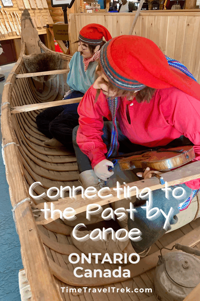 Pin image for TimeTravelTrek.com post with image of historically dressed mannequins in wood canoe. Text reads: Connecting to the Past by Canoe, Ontario, Canada.