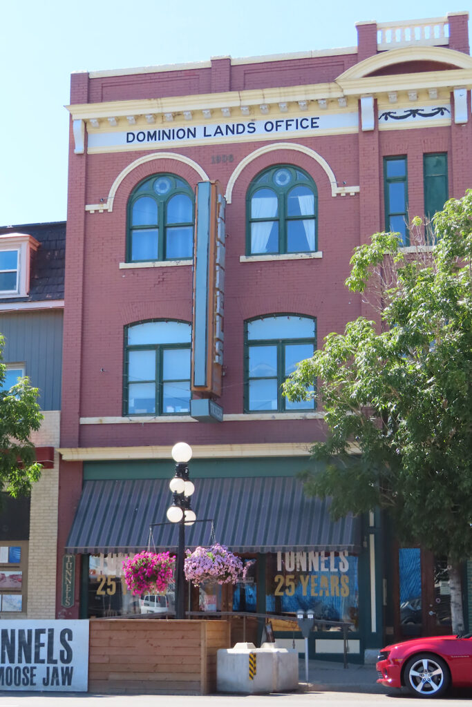 Historic red brick building with words "Dominion Land Office" written above upper windows.