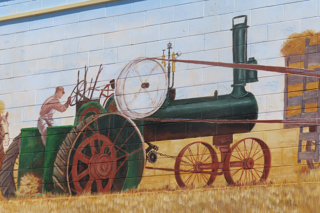 Painting of old tractor in field.