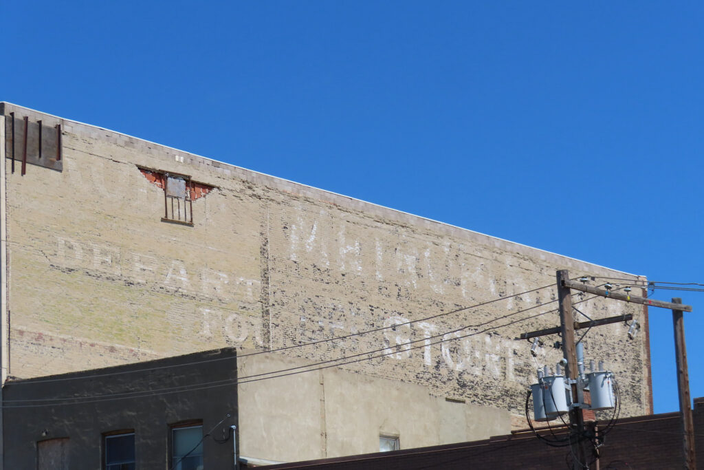 Faded white lettering on side of building.