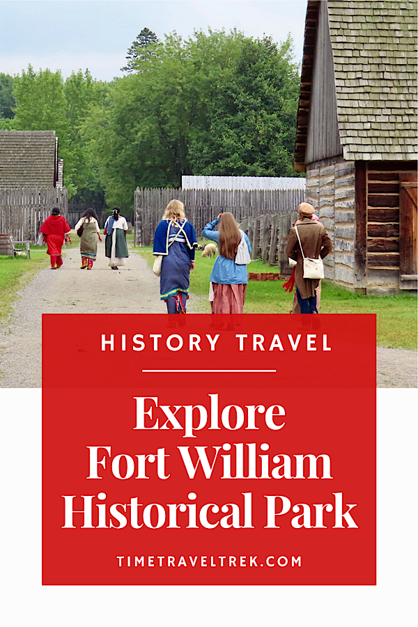 People dressed in 1800s fur trade-era clothing walking along dirt road past wooden buildings. Text reads: History Travel. Explore Fort William Historical Park. TimeTravelTrek.com