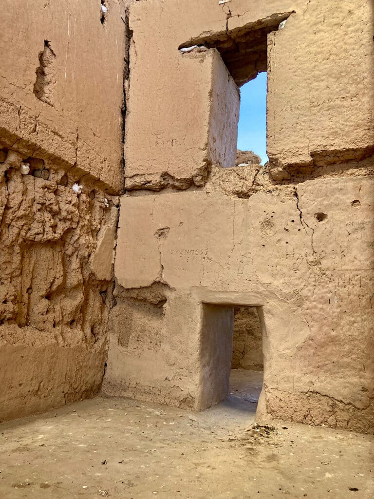 Large, two-storey adobe and stone building walls.