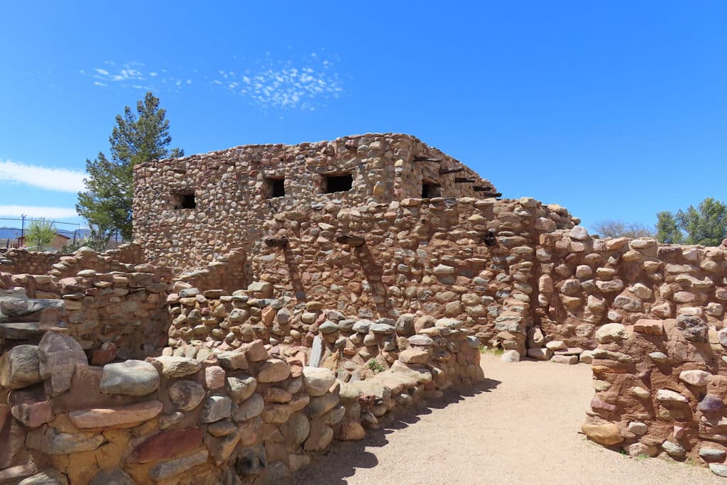 Rock building and walls under blue sky.