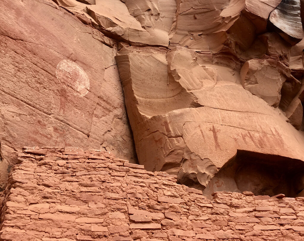 Built rock wall with rock paintings above.