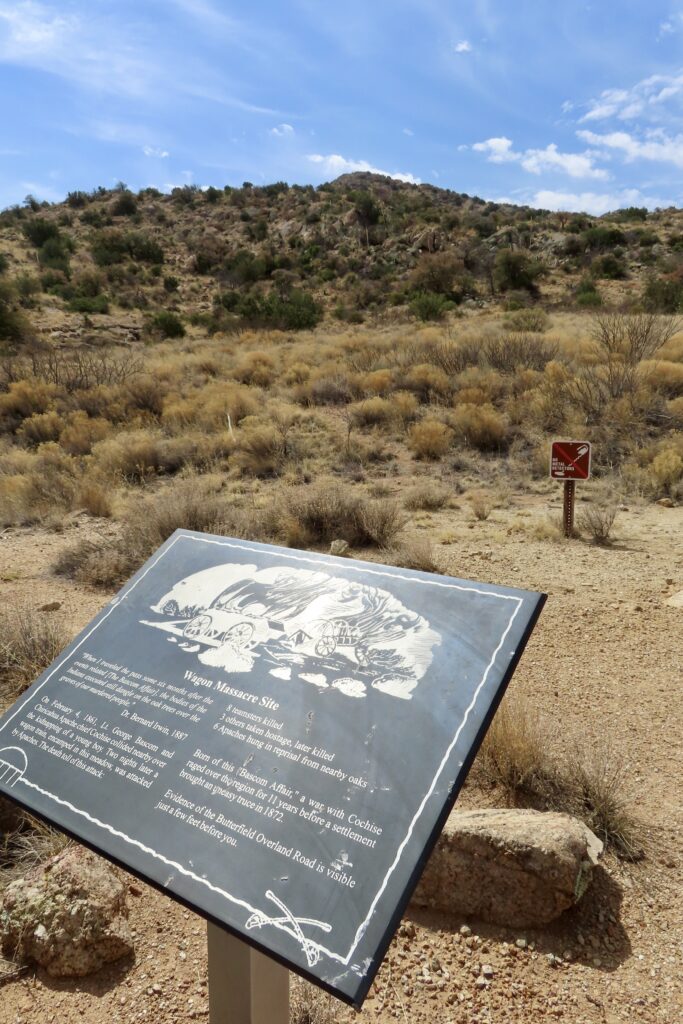 Interpretive sign overlooking dry desert landscape.