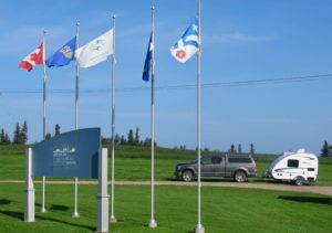 Entrance flags welcome visitors such as the owners of this truck and trailer to the Lac La Biche Mission Historic site in northeastern Alberta, Canada.