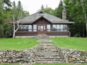 Log home with stone path and retaining wall