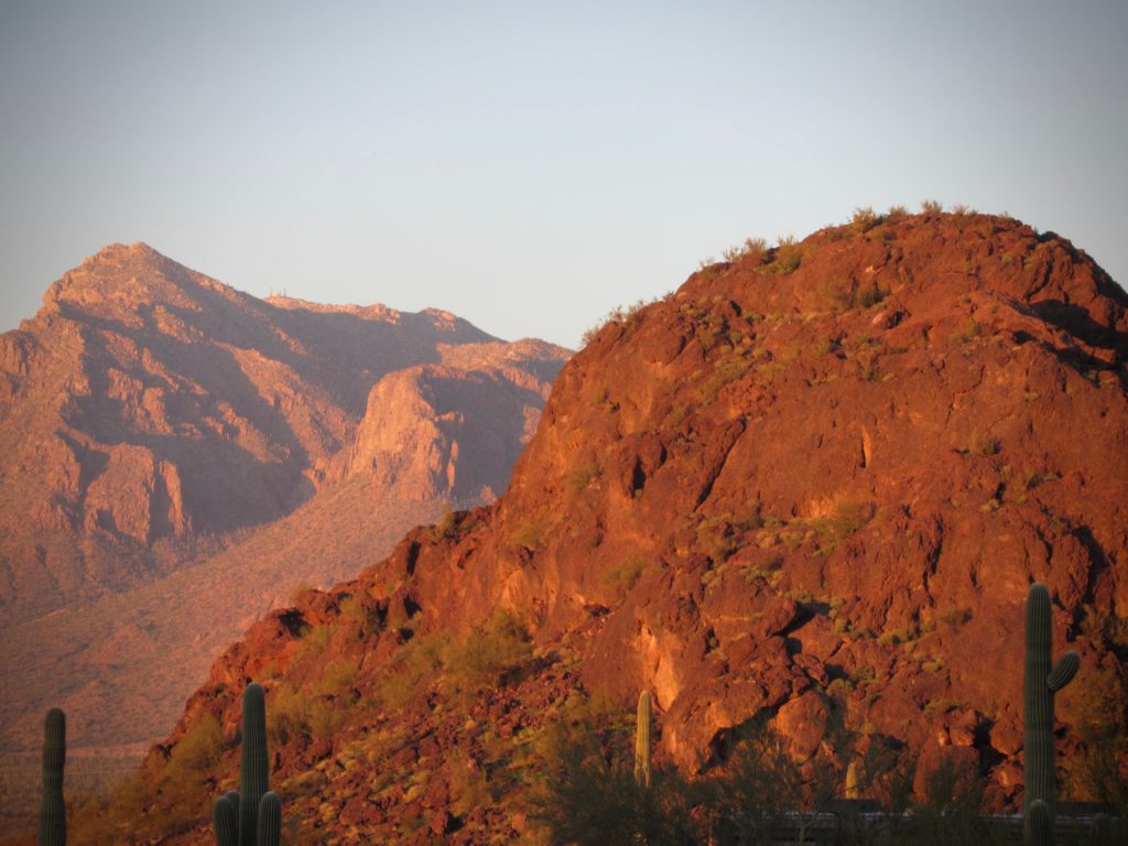 Distant mountains glow orange and red in sunset light.