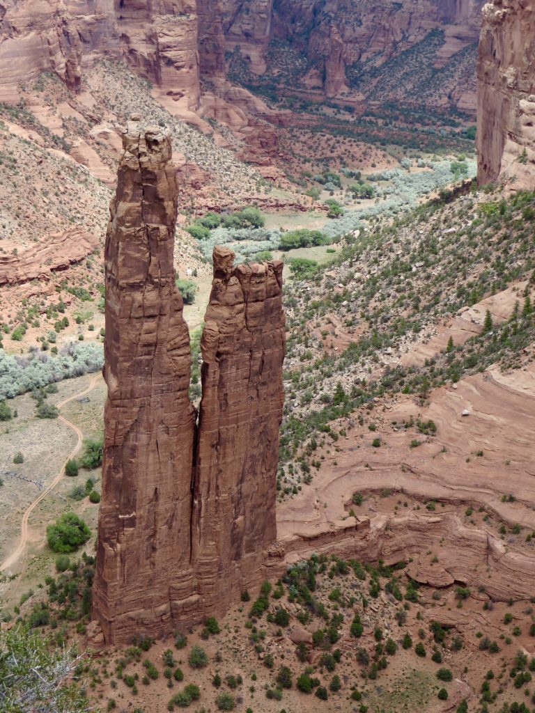 Twin sandstone towers in a deep red rock canyon.