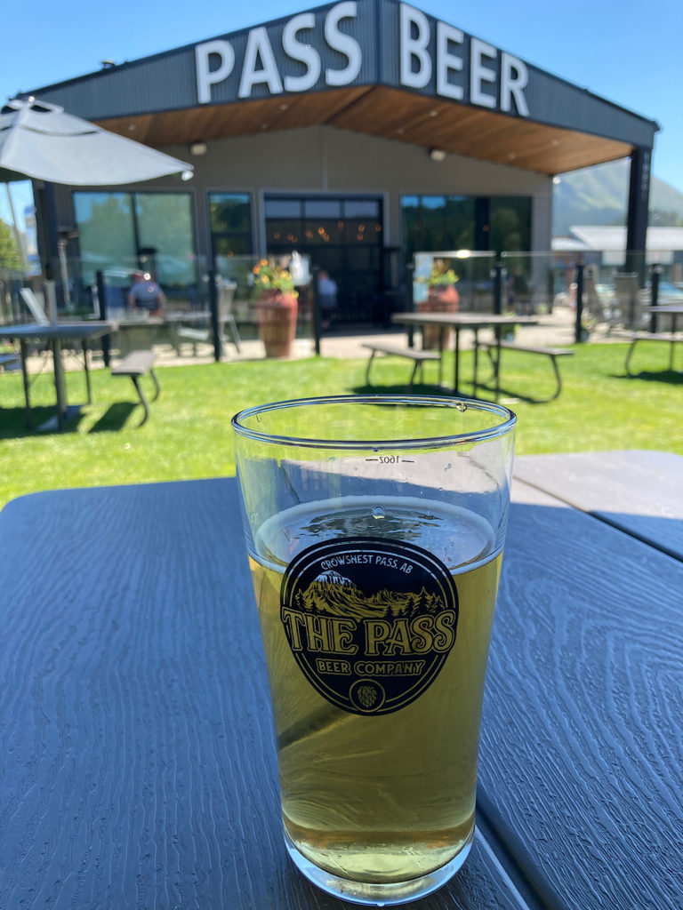 Glass of beer on table in patio of The Pass Beer Company.