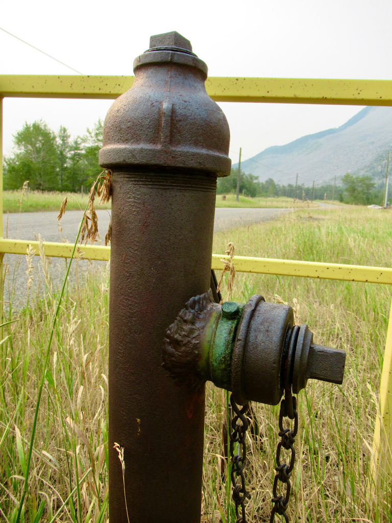 Old rusted brown metal fire hydrant.