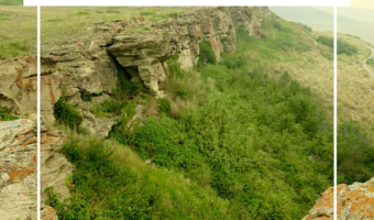 Text reading "Alberta Adventures: Head-Smashed-In Buffalo Jump" overlaying picture of green shrubby area below a brown sandstone cliff.