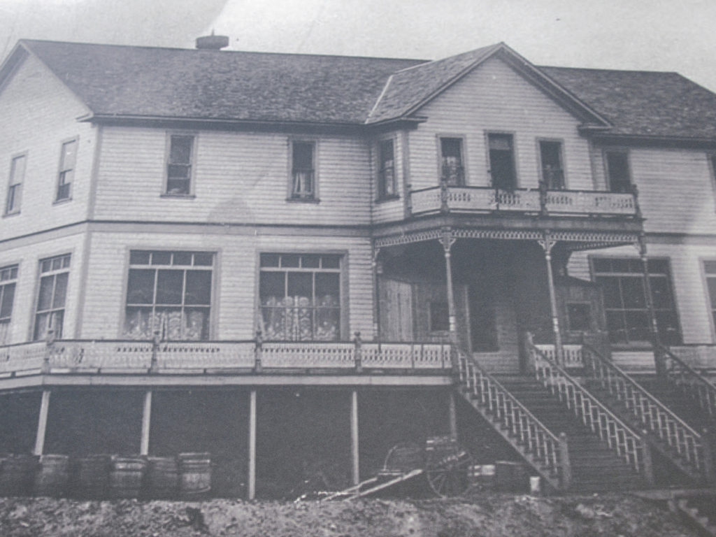 Black-and-white photo of large wooden hotel.