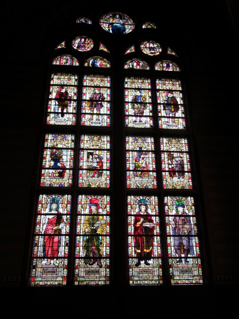 Large, multi-paned stained glass window with images of Dutch artists.