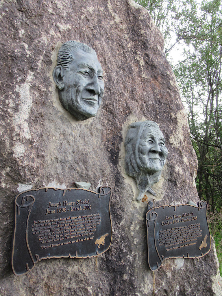 Large rock with two sculpted faces of a man and a woman and brass plaques with text below each.