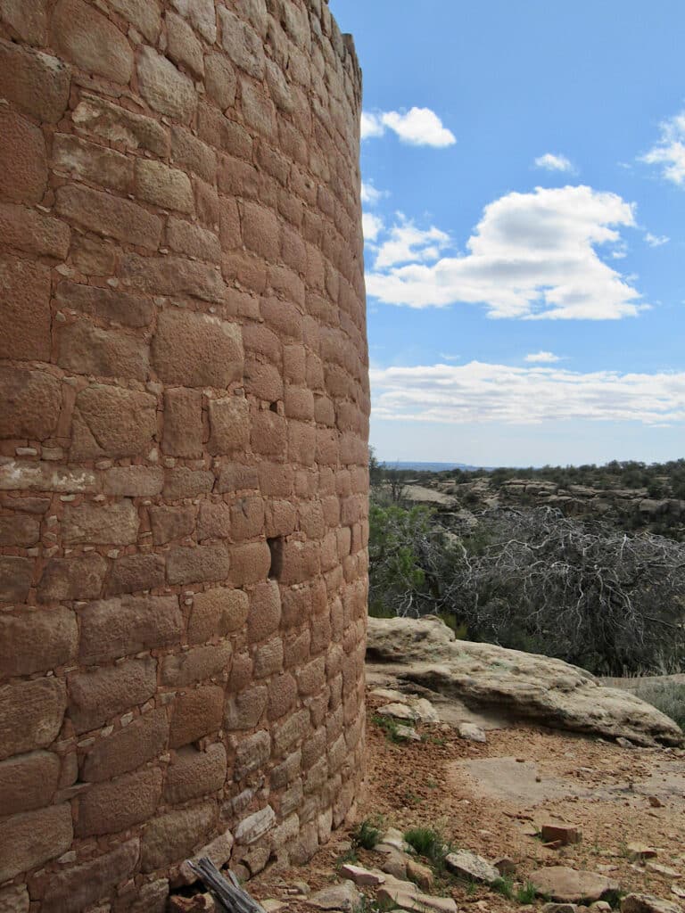 Close up view of masonry details of a round building on a canyon rim taking up half of the photo.