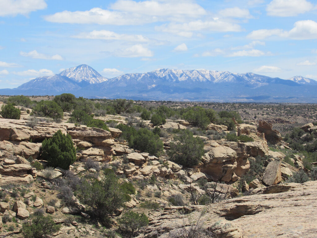 Distance mountain range resembling a person laying flat on their back with rocky canyon in foreground.