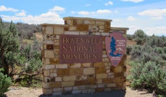 Plaque on stone base reading: Hovenweep National Monument. Wooden side plaque in shape of an arrowhead reading: National Park Service, Department of the Interior.