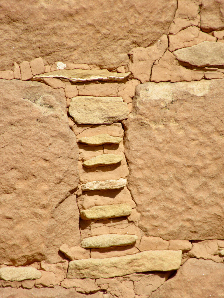 Vertical pattern of small flat rocks in dried mud in between larger stone.