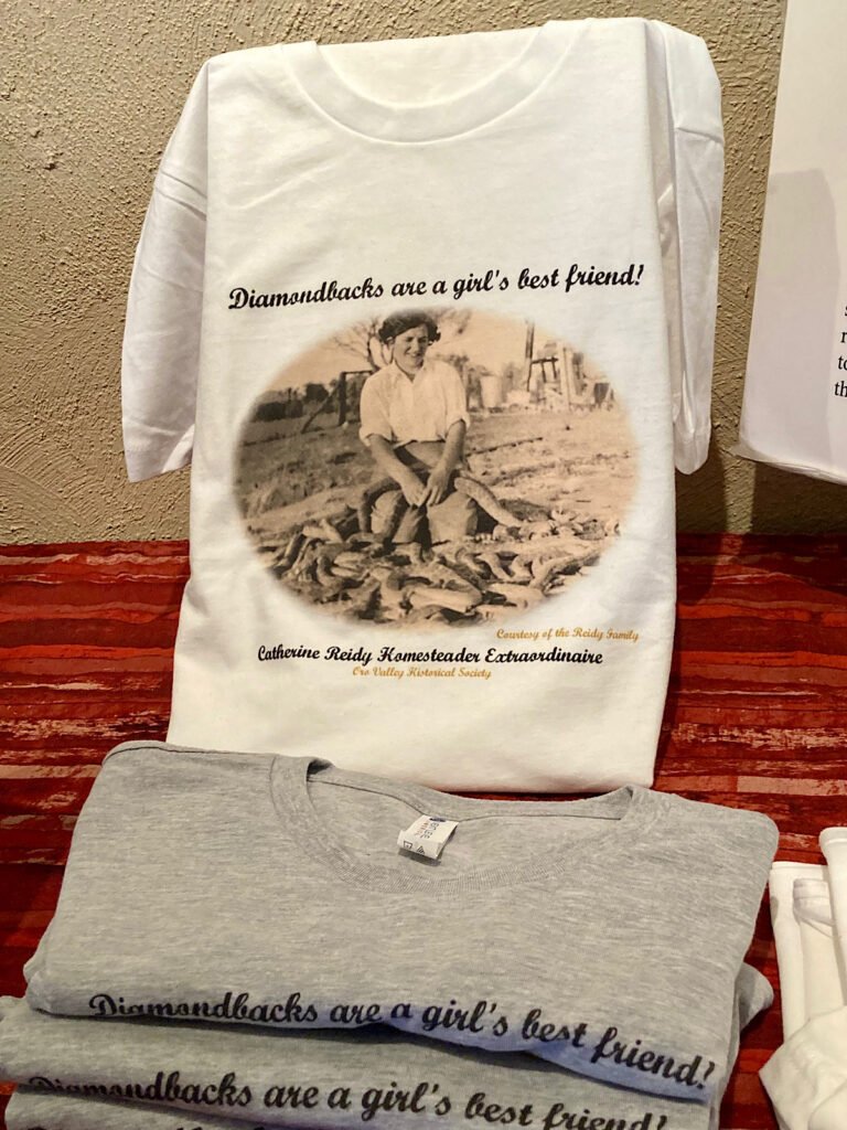 T-shirt in a display reading "Diamondbacks are a girl's best friend!" and showing picture of a woman surrounded by rattlesnakes.