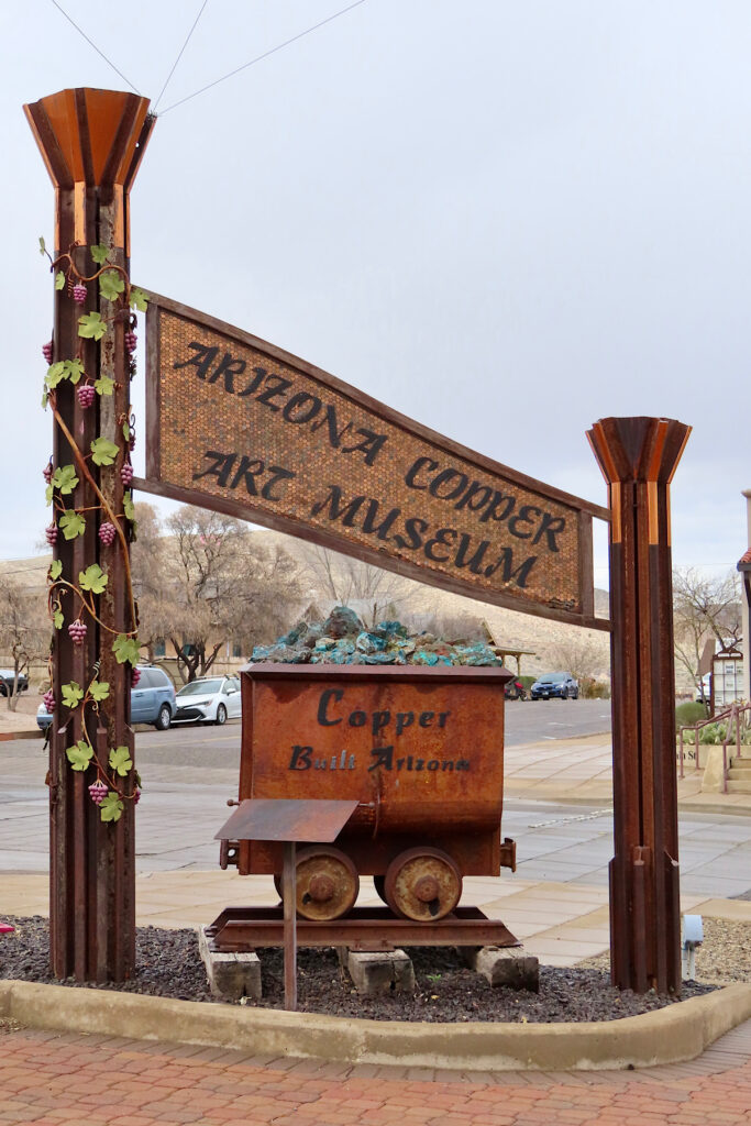 Sign reading "Arizona Copper Museum" above mining cart with words "Copper built Arizona" on side.