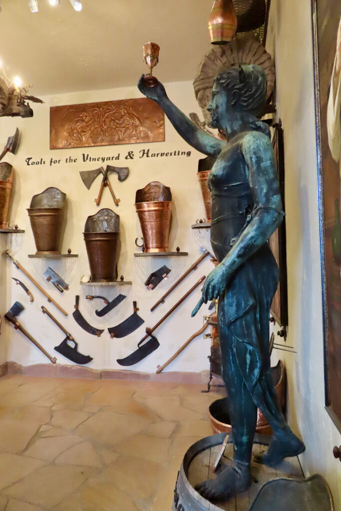 Three small images of copper art pieces above large image of a female copper statue raising a wine glass in a display labelled "Copper in the vineyard and harvesting."