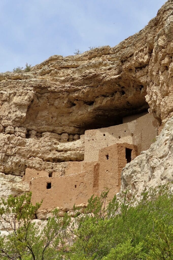 Multi-storey cliff dwelling partially tucked in large rocky cave.