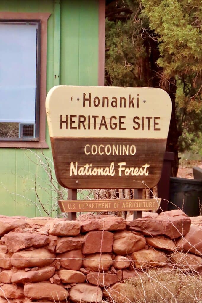 Sign in front of green building reading: Honanki Heritage Site, Coconino National Forest, U.S. Department of Agriculture.