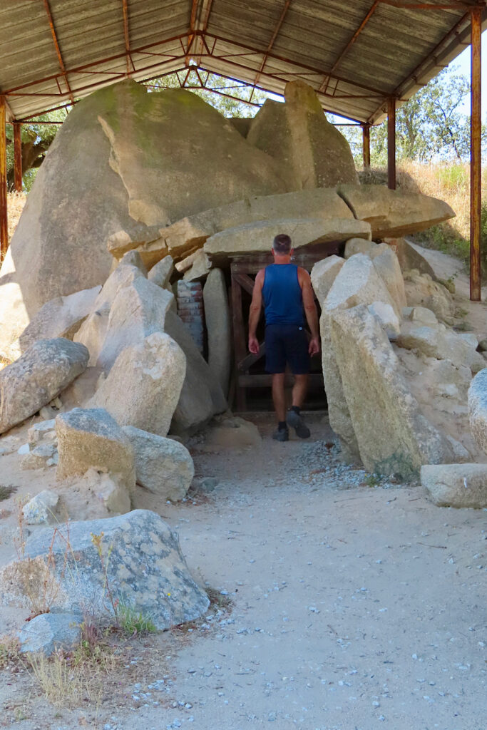 Man standing in doorway of large rock structure.